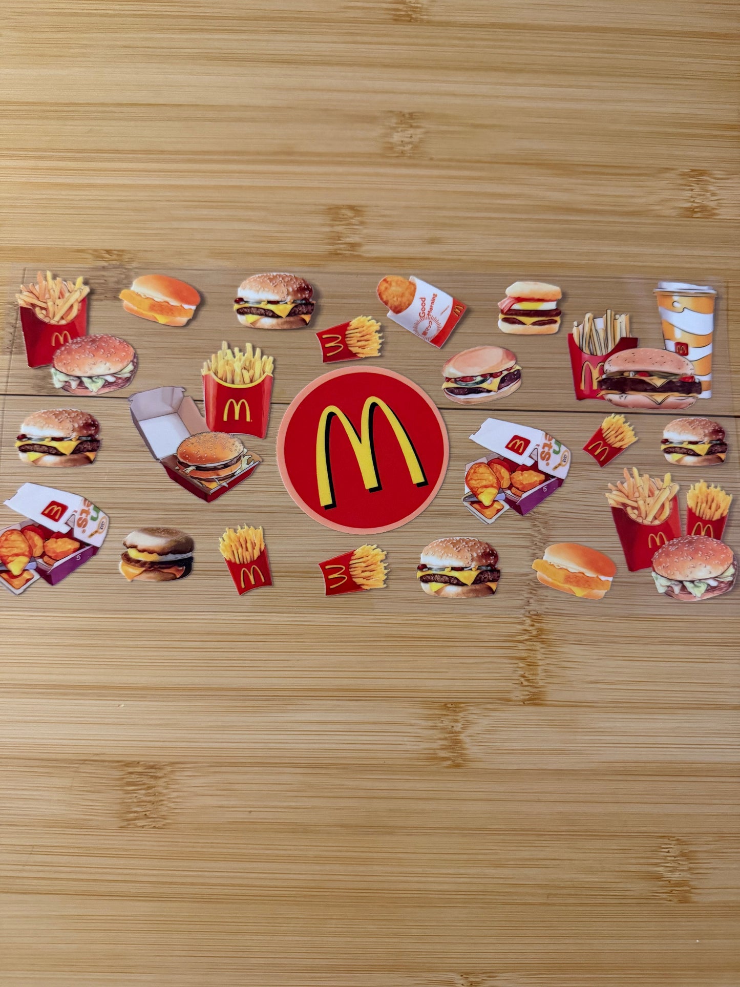 McDonald's logo surrounded by various food items on a wooden surface