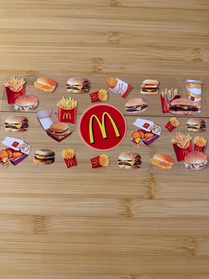 McDonald's logo surrounded by various food items on a wooden surface